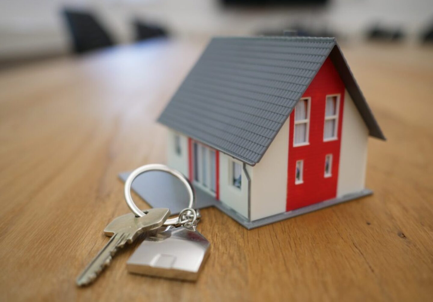 Photo by Tierra Mallorca white and red wooden house miniature on brown table